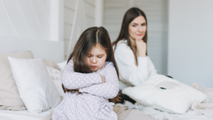 Enfant contrarié assis sur un lit, moment de colère avant l'apaisement